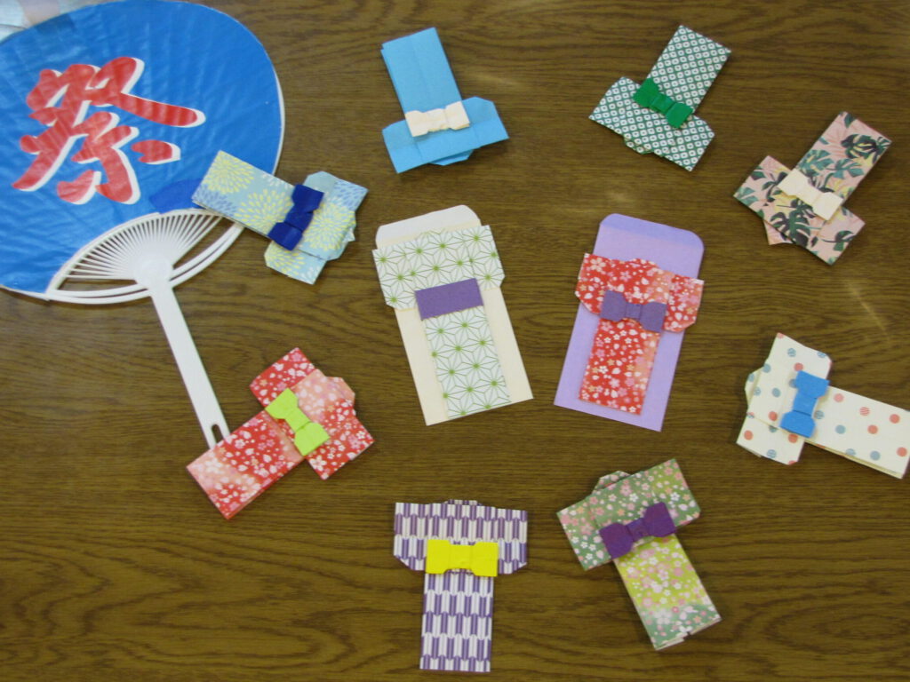 デイサービスのプログラムで浴衣のポチ袋を作成しました。 お好きな色の折り紙を選んで頂き、浴衣と、帯、ポチ袋を折り